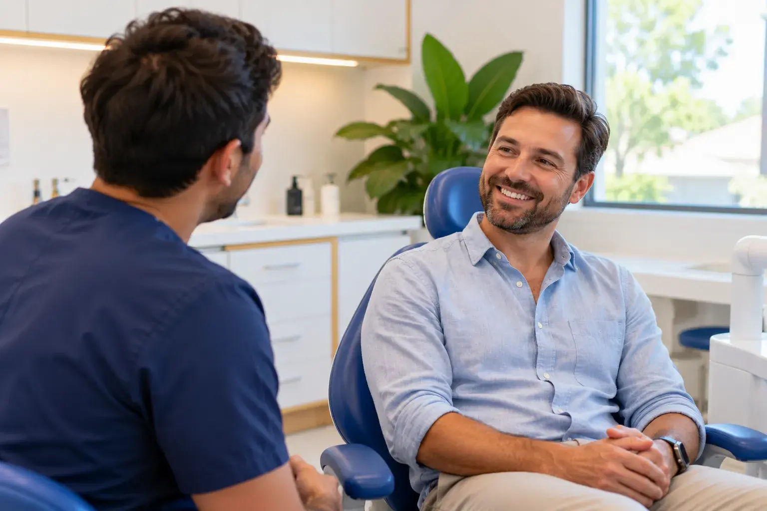 A relaxed adult chatting in the dental chair before a check-up